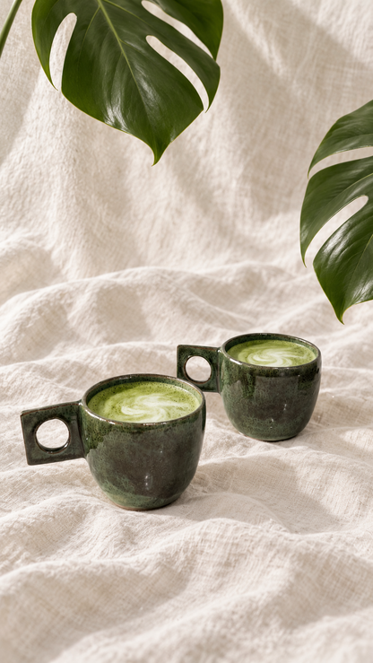 Forest green handmade ceramic mug with mottled glaze and a rectangular handle with a circular opening