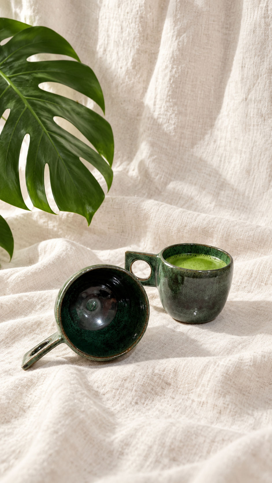 Forest green handmade ceramic mug with mottled glaze and a rectangular handle with a circular opening